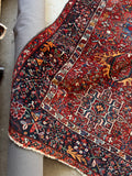 Vintage Persian Heriz gallery rug. Antique wool carpet featuring vibrant vegetable-dyed colors, a midnight blue border, and lively tribal artwork.
