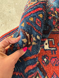 Antique village woven Persian rug with punchy red field and navy medallion, sturdy low pile wool construction.
