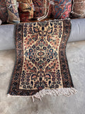 Fringe and selvedge detail Lilihan rug showing the handmade floral design and woven fringe trim.