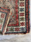 Close-up view of hand-knotted vegetable-dyed wool fibers on a late 1800s Caucasian tribal rug.