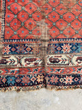 Distressed turn-of-the-century Persian rug in terracotta and teal green and floral borders for bedroom or study decor.