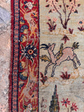 Small Persian pictorial accent rug full view showing an equestrian hunting scene framed by a rich red floral border.