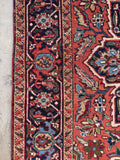 Authentic 1920s Persian Heriz carpet detailed view of the deep navy primary border with repeating rosette and leaf designs.