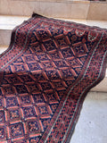 Authentic Baluch bedside rug 3x4 angled perspective showing flat weave edges and slight vintage selvedge wear.