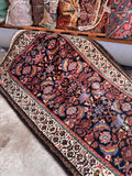 Midnight blue Persian hallway runner angle shot displaying the deep blue ground color and contrasting ivory border.
