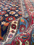 Authentic 1940s Persian rug rolled showing texture and wool pile.