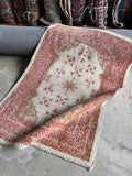 Turkish wool accent rug displaying an airy open field framed by intricate berry red and camel borders.