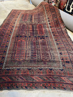 Full view of antique Baluch rug with visible wear.