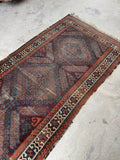 Handwoven Persian Baluchi runner with muddy red, brown, and blue tribal geometric design.