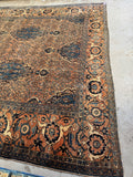 Large antique Persian rug with grand medallions and flowing tribal design.