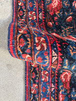Close up border angle of the rug capturing its dense texture and pattern.
