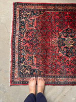 One end of rug featuring fine border details and abrashed coral color.