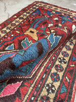 Persian rug with blossom-laden vine borders in rich colors.