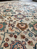 Handwoven rug with intricate paisley and floral patterns.