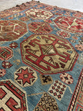 Close view of hexagon medallion and eight pointed star motifs in an antique Caucasian rug.