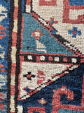 Close up vintage Kazak hallway runner with primitive tribal artistry and bold contrast.