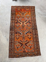 Mid-century Kurdish rug with orange hues.