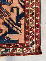 Corner shot of rug displaying floral and tribal elements.