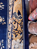 Restored antique Chinese Peking rug detail shot of a gold border band with botanical motifs.