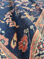 Corner of main field with floral motifs against a deep navy blue ground.