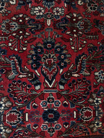 Close up of floral motifs against a deep brick red ground.