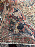 Corner close-up of faded Herati motif on main border band with visible aging.