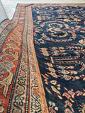 Brick red main border with stylized vine chain on a 1920s Mahal rug.