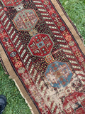 Close-up of a patterned rug with geometric designs on a grassy background