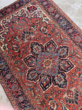 Vintage Northwest Persian tribal rug angled perspective showing the full 5'6 x 9'4 size laid flat on a neutral floor.