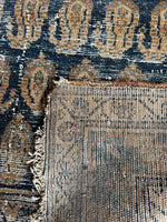 Handwoven wool rug showing signs of use and strong construction.