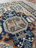 Close up of vegetable dyed wool Caucasian rug with symbolic power motifs.