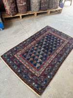 Near mint condition antique Caucasian rug with rich navy background.