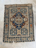 Antique Caucasus mountain rug with protective tribal motifs and geometric design.