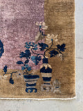 Corner detail with potted floral motif in blue on camel border.