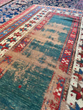 Rare open field Kazak rug in earthy green with hand knotted tribal craftsmanship.