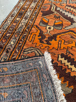 Underside view of weave texture with strong patterns and color pops across the Persian rug.