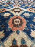 Close up of a vintage Persian Veramin carpet highlighting ivory latticework over a deep blue background.