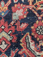 Close up view of early 1900s Persian rug with navy, mint, and ivory color palette and a whimsical bird motif.