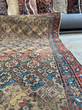Antique wool Persian rug, collectible Bidjar rug with eight-pointed star pattern, naturally aged colors, scattered wear, and dense handmade construction.
