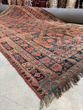View of late 19th century Persian nomadic rug with diamond layout and protective motif borders.