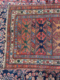 Antique Persian Bidjar rug close-up showing its geometric design and worn wool texture.