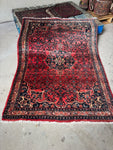 Full view of antique 1940s Persian Bidjar rug with coral abrashed ground.