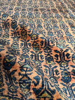 Close-up of antique Persian Sarouk rug showing luminous wool and detailed floral motifs.