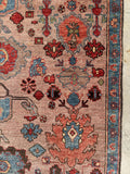 Close-up of serrated medallions and hooked motifs on Heriz rug.