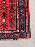 Vintage 1920s Persian runner rug featuring hand-knotted luxe wool and bold tribal motifs.