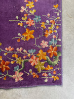 Close-up of floral corner design with orange, pink, and blue blossoms.