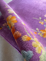 Close-up of vine and colorful flowers against purple ground