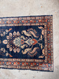 Antique runner rug one end view showing color story and floral design.