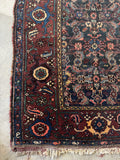 Corner view of hand knotted Persian village rug featuring fish motifs and tribal artistry throughout the field.