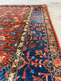 Deep navy floral border on handwoven Persian rug.